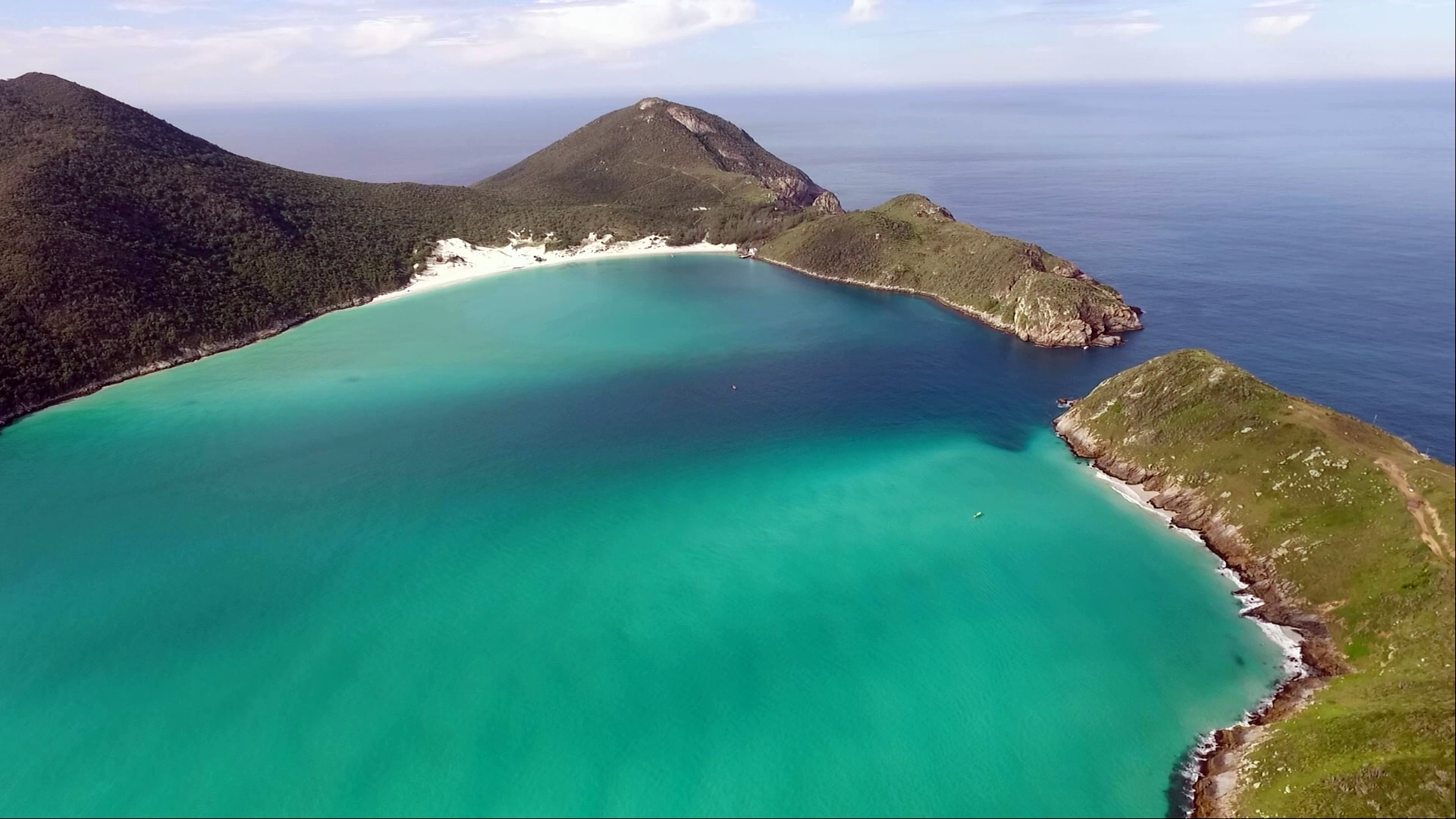 Vista panorâmica aérea de Arraial do Cabo com as praias turquesa, a Ilha do Farol e o Atlântico ao fundo