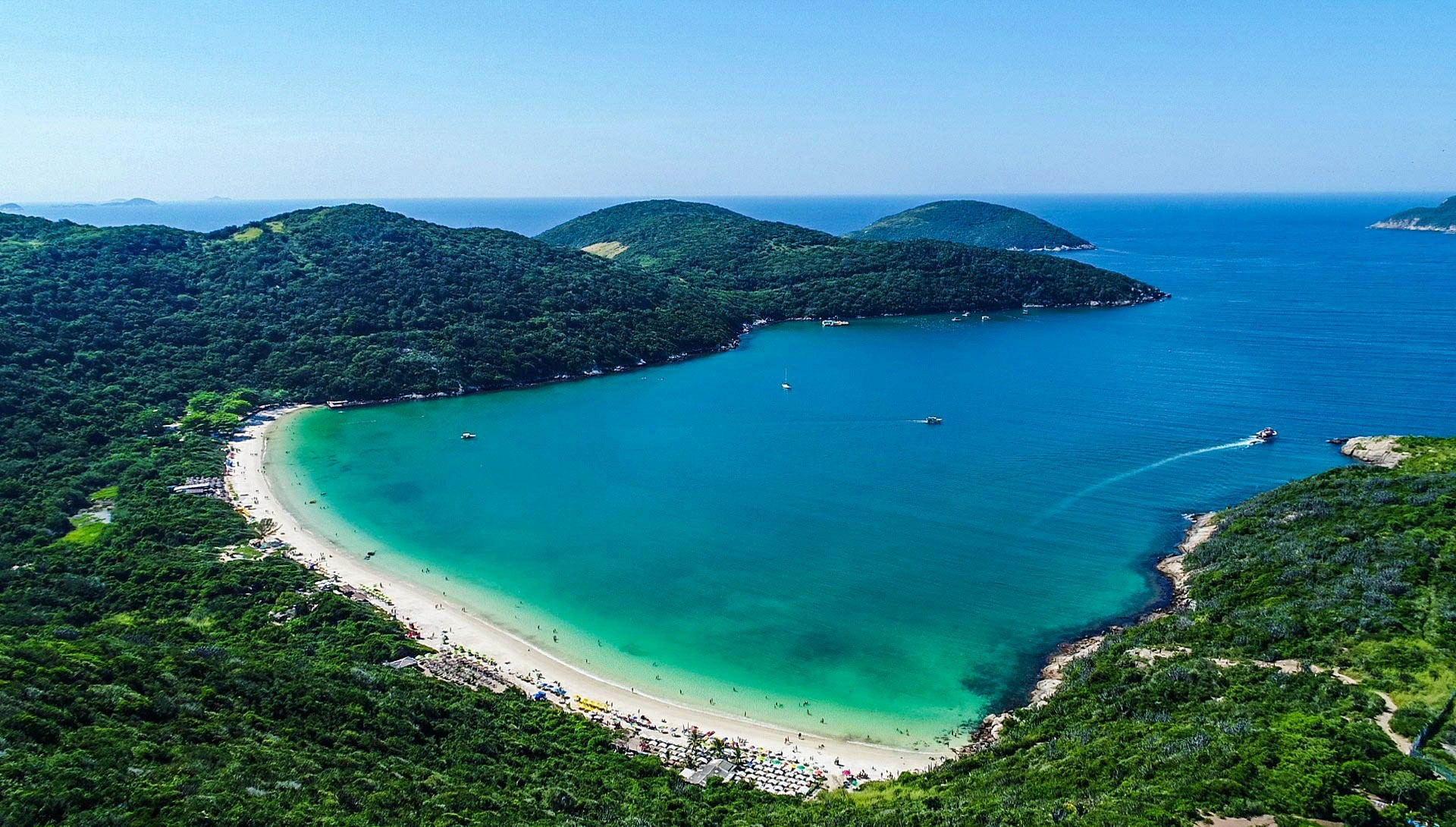 Praia do Forno de Arraial do Cabo vista do drone, com as águas claras e o entorno de mata e costão