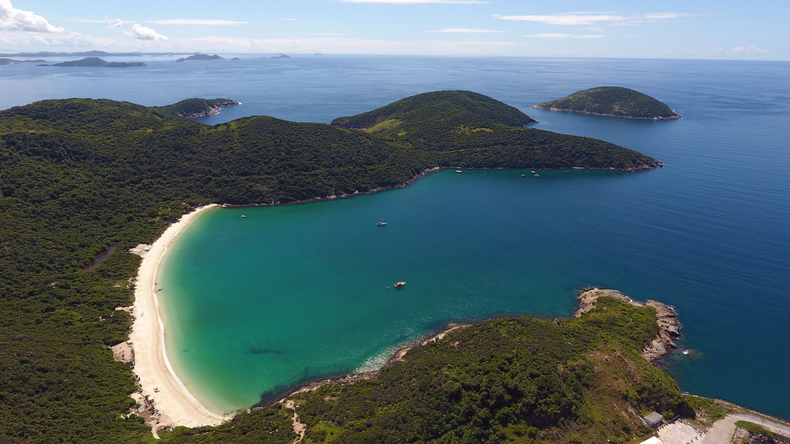 Praia do Forno en Arraial do Cabo, una cala de arena blanca y agua verdosa rodeada de cerros e islas